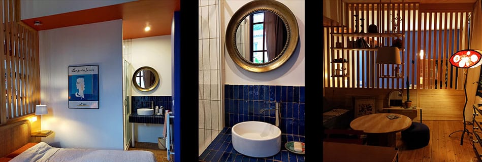 Coin nuit et salle de bain habillée de bejmat bleu Majorelle, vasque ronde et miroir doré, derrière la paroi en bois