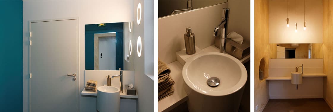 Sanitaires : WC au mur bleu canard et miroir lumineux, vasque ronde et point d'eau aux ampoules suspendues dans une niche enduite